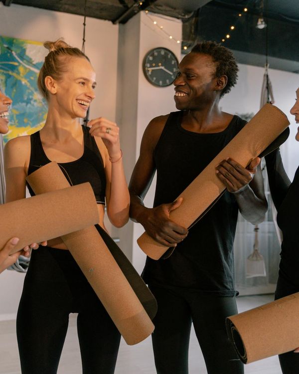 Diverse group of smiling people in comfortable yoga attire.
